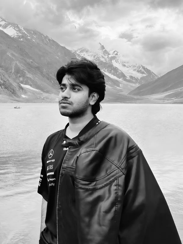 Qasver Ali, standing at the shore of a mountain lake in northern Pakistan.